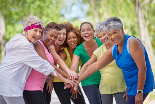 group of women joggers putting all hands in as a team